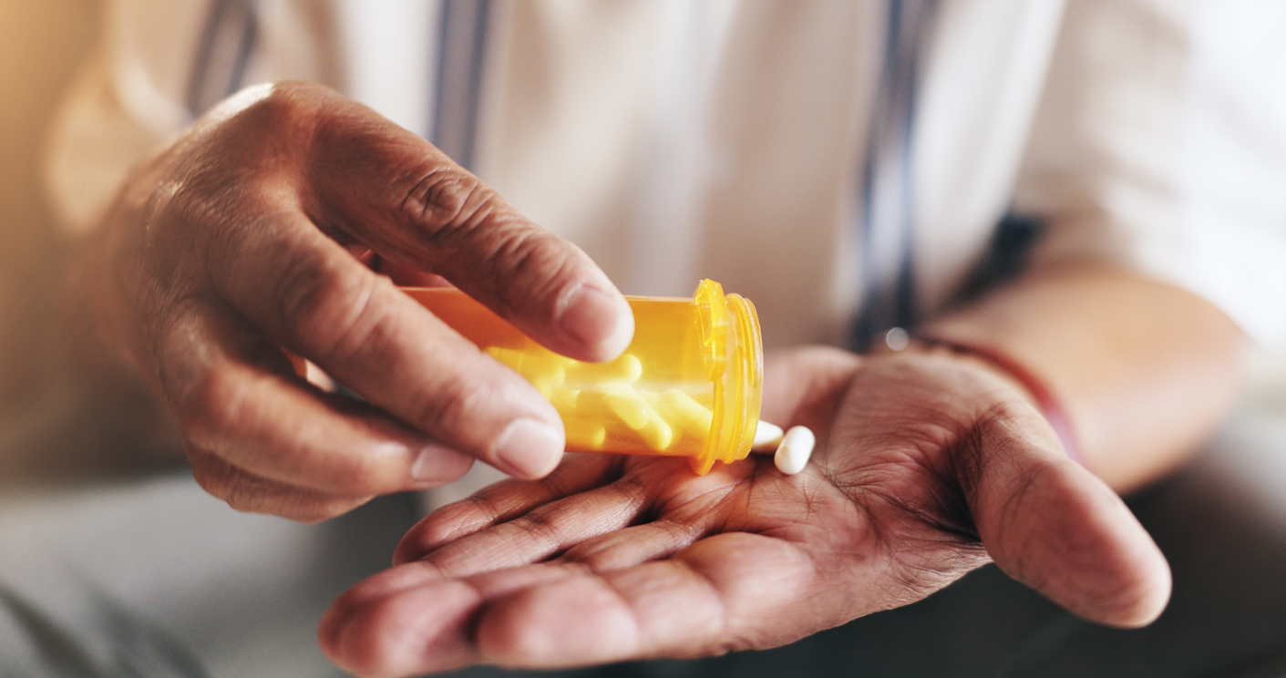 Hands, pills and bottle in closeup